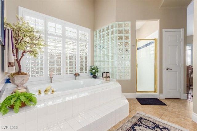 full bathroom with a shower stall, a bath, and tile patterned floors