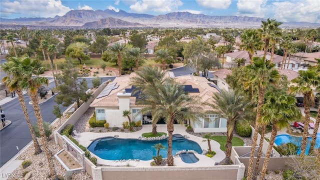 view of pool featuring a pool with connected hot tub, a residential view, and a mountain view