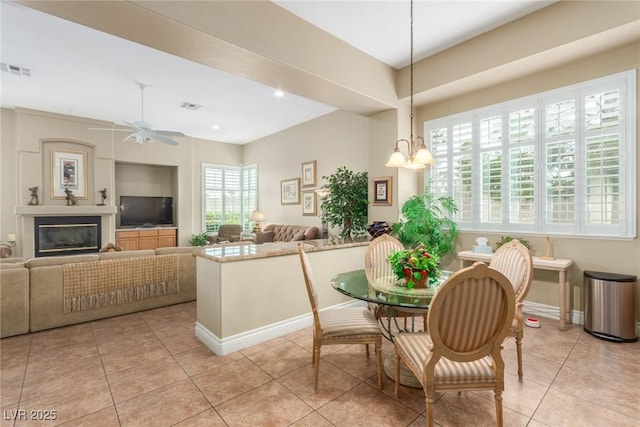 kitchen featuring a glass covered fireplace, visible vents, baseboards, and light tile patterned floors