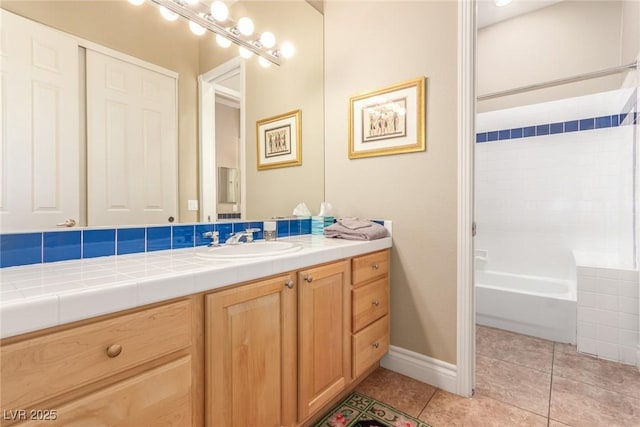 full bath with baseboards, shower / tub combination, vanity, and tile patterned floors