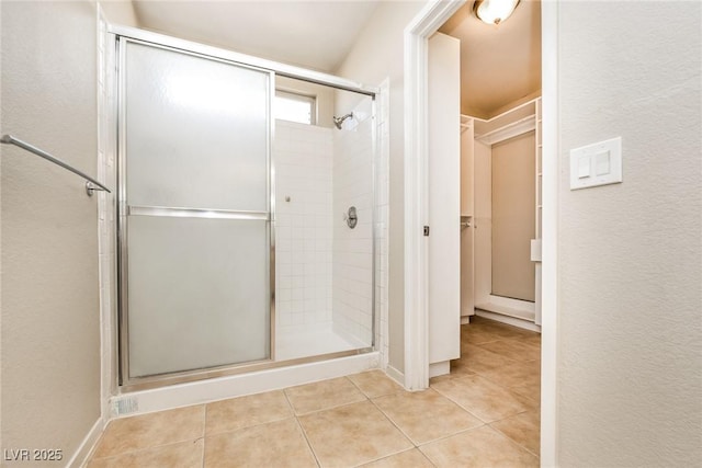 bathroom with tile patterned flooring and a shower stall