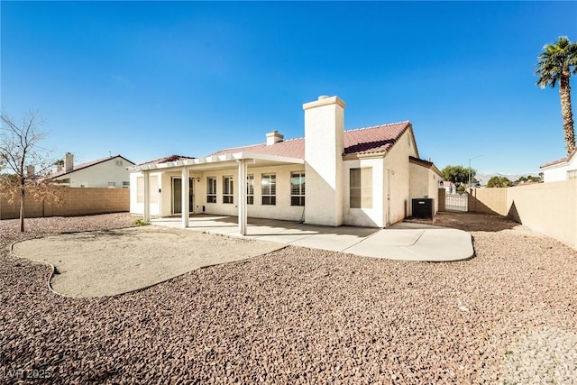 rear view of house with a patio, stucco siding, a fenced backyard, and central air condition unit