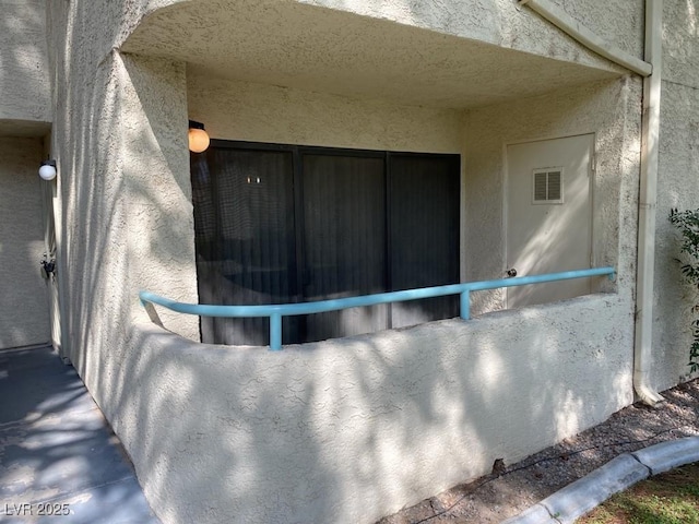 exterior details featuring visible vents and stucco siding