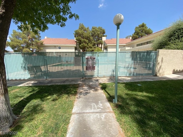 view of gate featuring fence and a lawn