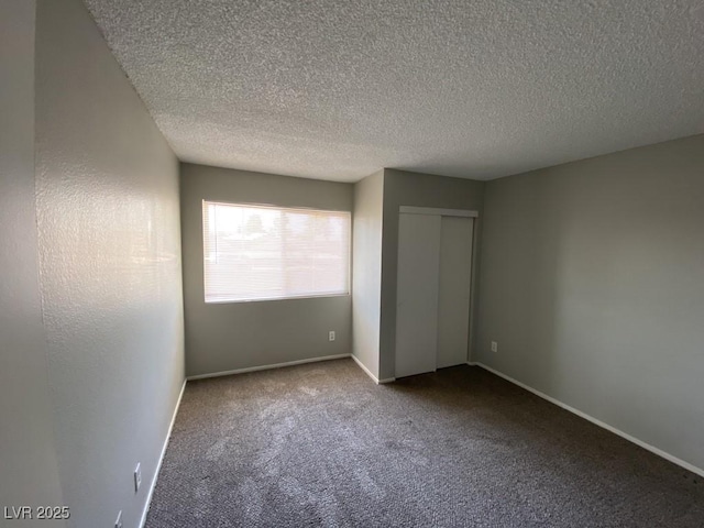 unfurnished bedroom with carpet, a textured ceiling, baseboards, and a closet