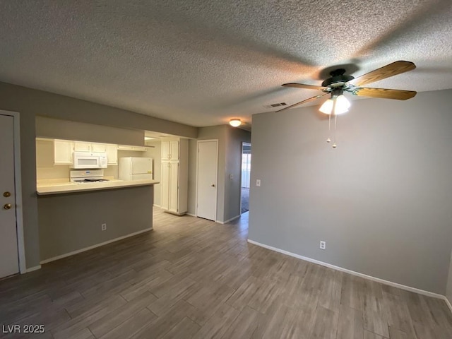 unfurnished living room featuring visible vents, dark wood-type flooring, a ceiling fan, a textured ceiling, and baseboards