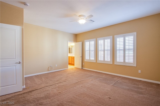 spare room with light carpet, ceiling fan, visible vents, and baseboards