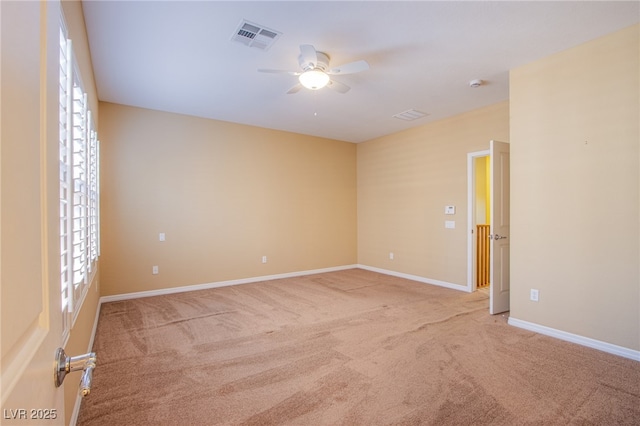 carpeted empty room with a ceiling fan, visible vents, and baseboards