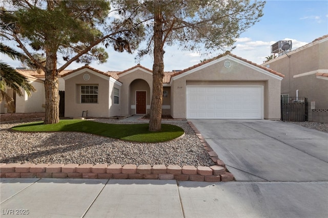 view of front of property featuring driveway, a garage, central AC unit, fence, and stucco siding