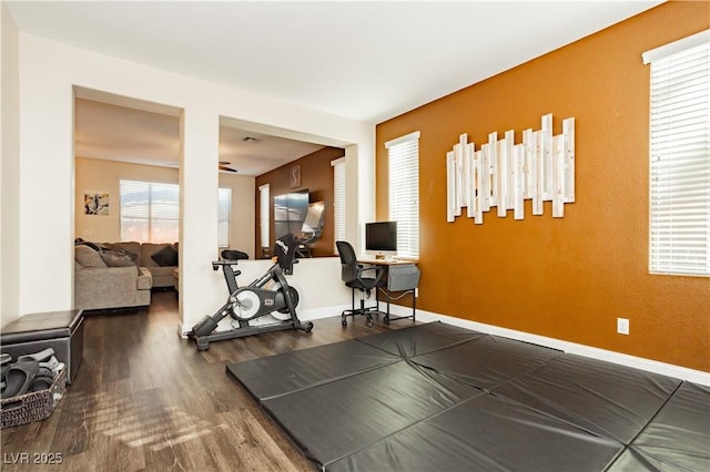 exercise area with wood finished floors and baseboards