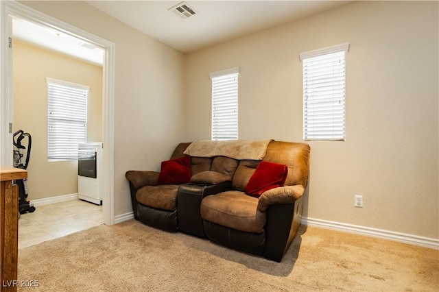 living room with carpet, visible vents, and baseboards