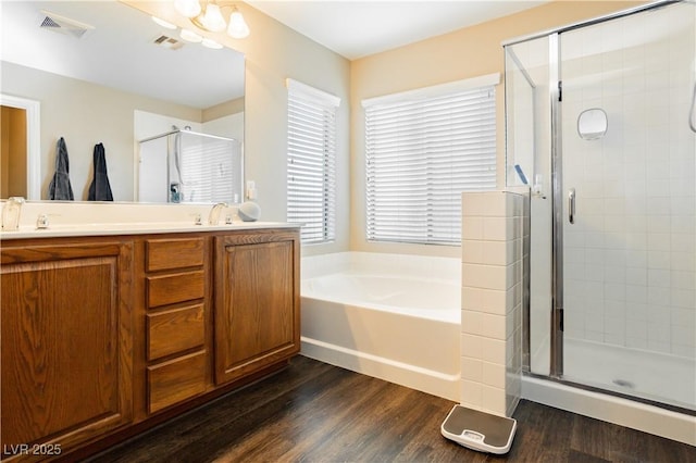 bathroom with a shower stall, visible vents, and wood finished floors