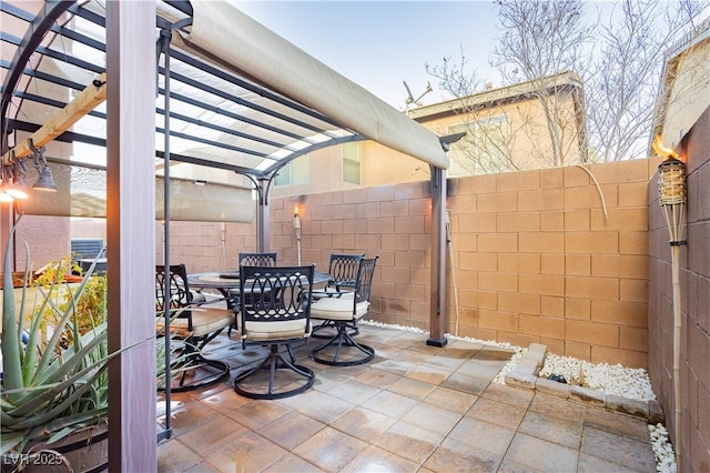 view of patio featuring fence, a pergola, and outdoor dining space