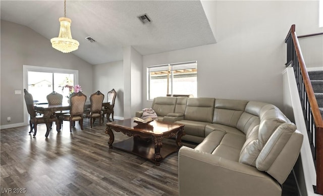 living room featuring a wealth of natural light, visible vents, vaulted ceiling, and stairs