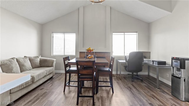 dining space with lofted ceiling, wood finished floors, and baseboards