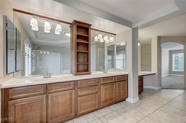 full bathroom with tile patterned flooring, a sink, visible vents, double vanity, and a tray ceiling