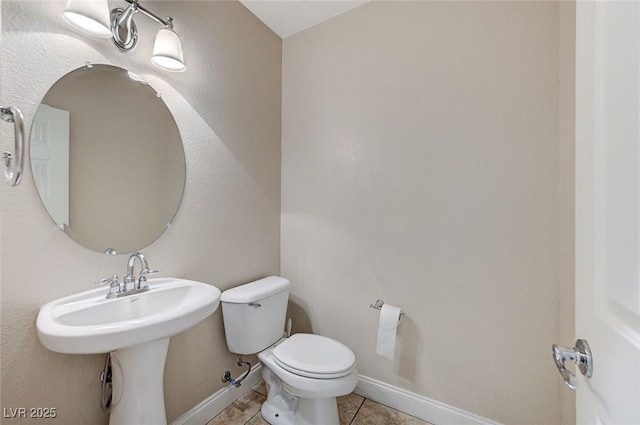 bathroom featuring baseboards, toilet, and tile patterned floors