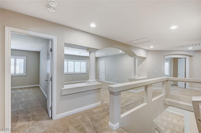 interior space featuring a healthy amount of sunlight, decorative columns, visible vents, and carpet flooring