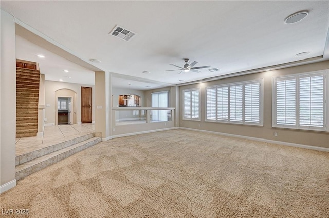 unfurnished room with ceiling fan, carpet floors, visible vents, and baseboards