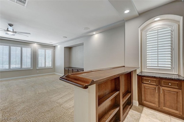 interior space featuring recessed lighting, visible vents, light colored carpet, a ceiling fan, and baseboards