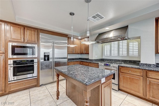 kitchen with built in appliances, light tile patterned floors, a kitchen island, exhaust hood, and visible vents