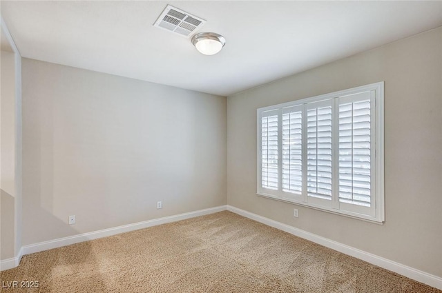 unfurnished room with carpet floors, visible vents, and baseboards