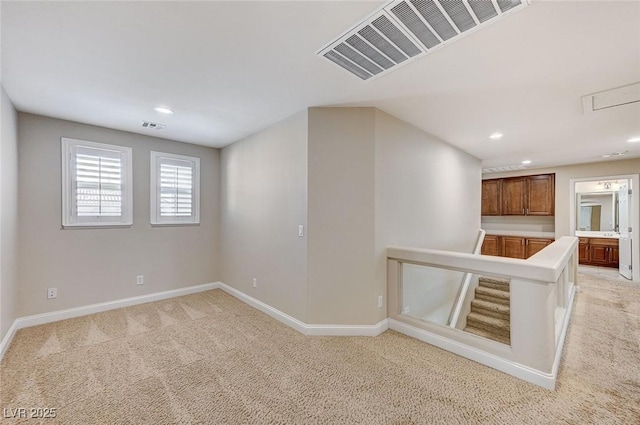 interior space with recessed lighting, light carpet, visible vents, and baseboards