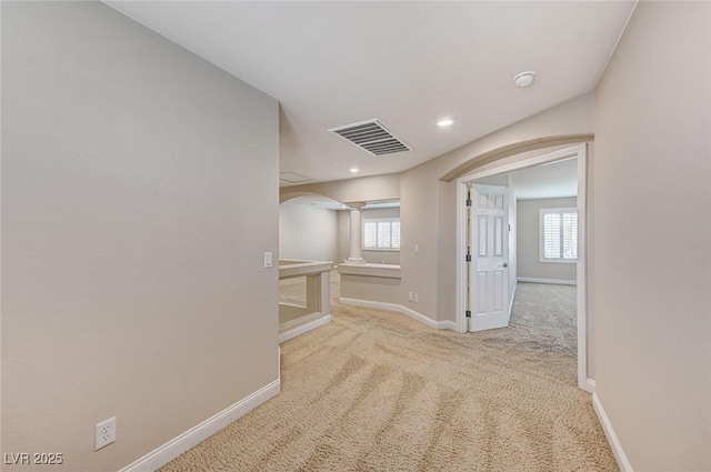 hall featuring arched walkways, recessed lighting, visible vents, baseboards, and carpet