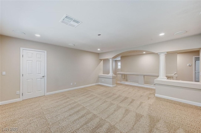 unfurnished living room featuring baseboards, carpet, visible vents, and ornate columns