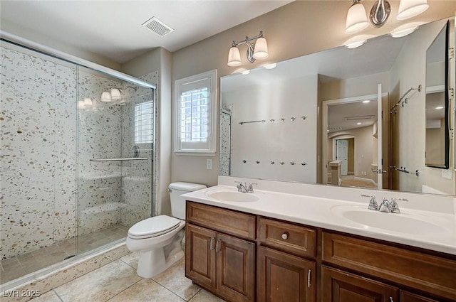 full bath featuring toilet, a sink, visible vents, and a shower stall