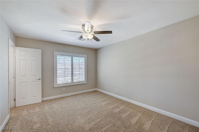 spare room with baseboards and light colored carpet