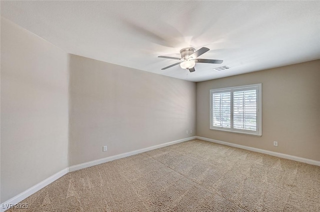 spare room with baseboards, a ceiling fan, visible vents, and light colored carpet