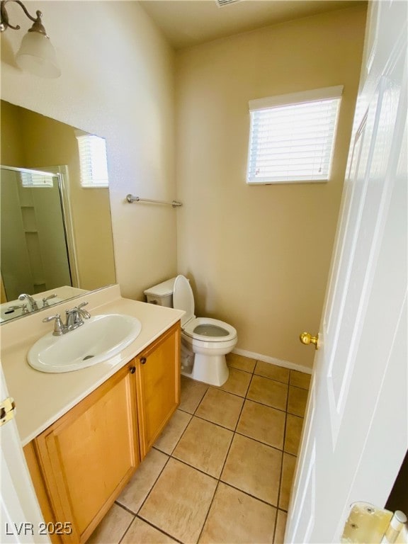 full bathroom featuring toilet, a stall shower, vanity, baseboards, and tile patterned floors