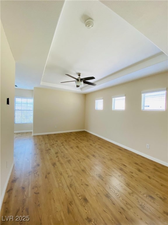 empty room featuring light wood-type flooring, a healthy amount of sunlight, and baseboards