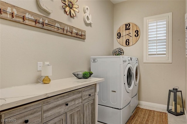 laundry area with light tile patterned floors, baseboards, cabinet space, and independent washer and dryer