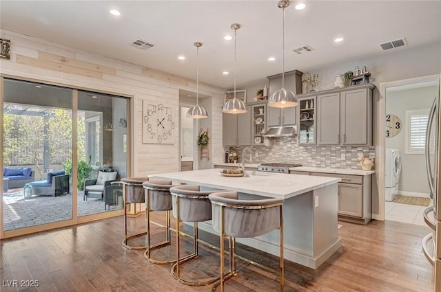 kitchen with visible vents, light countertops, decorative backsplash, and gray cabinetry