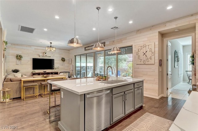 kitchen featuring a sink, visible vents, open floor plan, gray cabinets, and dishwasher