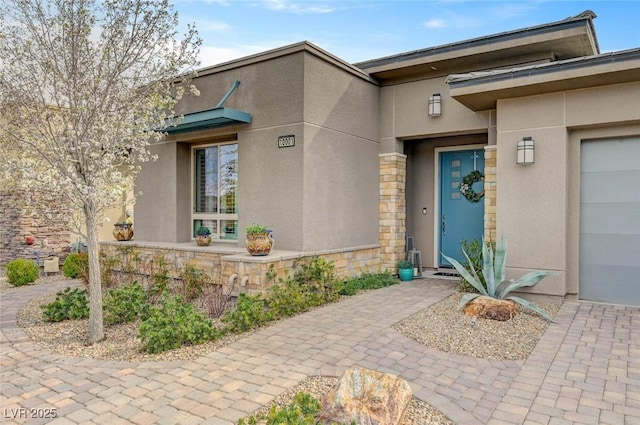 entrance to property featuring stone siding and stucco siding