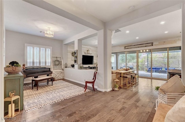 living area with recessed lighting, visible vents, baseboards, and wood finished floors