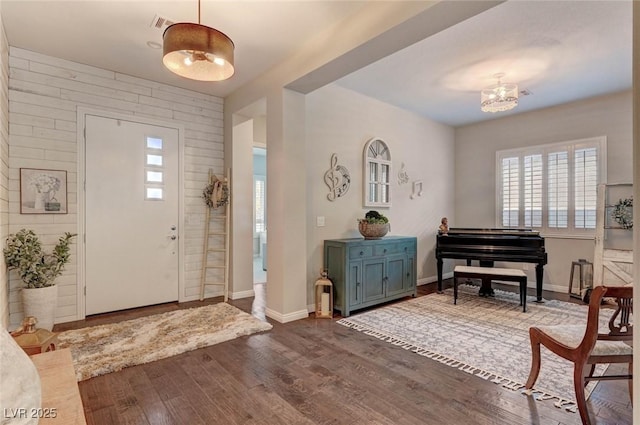 entryway featuring a chandelier, dark wood-style flooring, visible vents, and baseboards