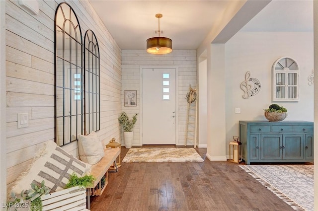 entrance foyer with dark wood-type flooring and baseboards