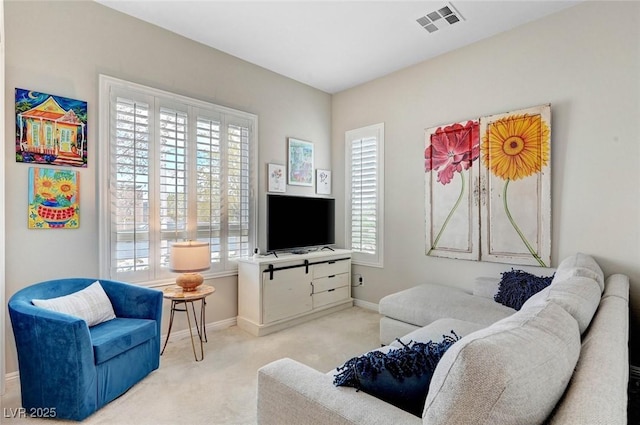 carpeted living area with visible vents and baseboards