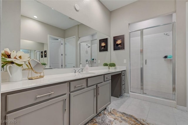 full bath with tile patterned floors, a shower stall, baseboards, and vanity