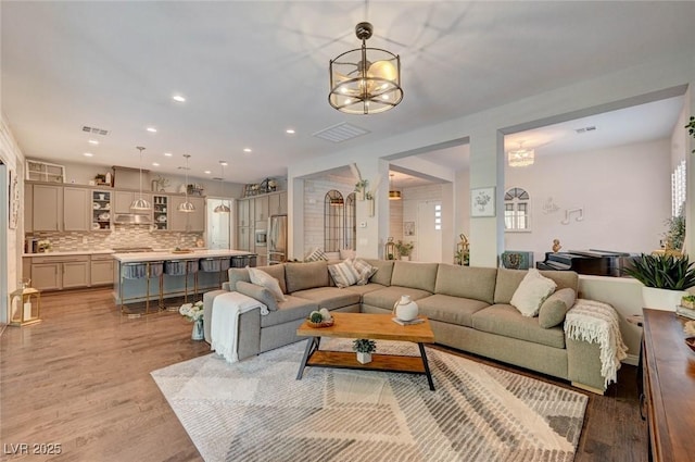 living area with light wood-type flooring, visible vents, and recessed lighting