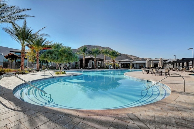 community pool with a patio area and a mountain view