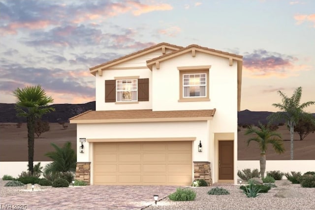 view of front of property featuring stone siding, decorative driveway, an attached garage, and stucco siding