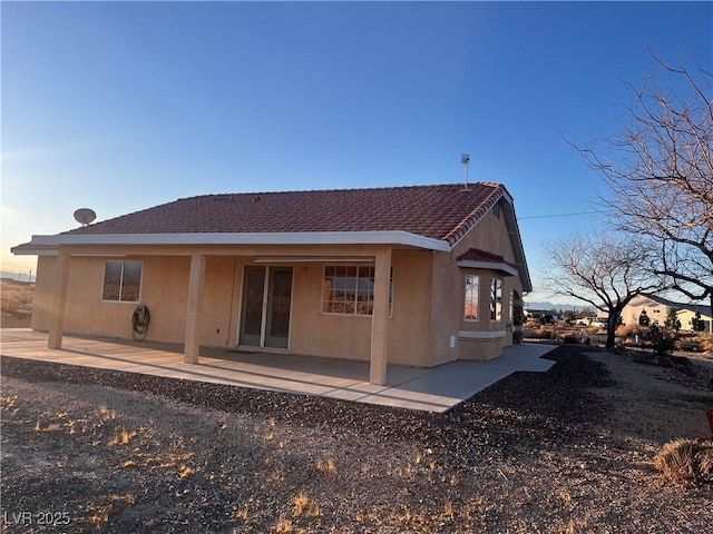 rear view of house with a patio area and stucco siding