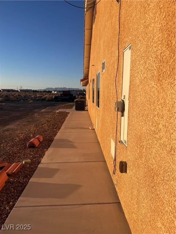 view of home's exterior with cooling unit and stucco siding