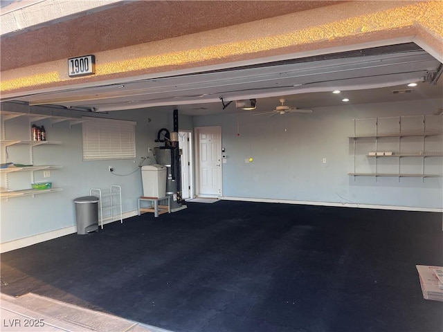 garage featuring a garage door opener, water heater, baseboards, and a ceiling fan