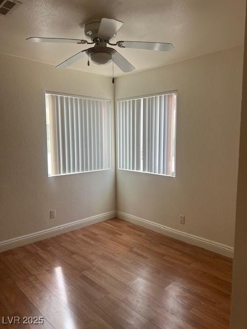 unfurnished room with visible vents, ceiling fan, baseboards, and wood finished floors